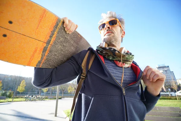 Skateboardista držení skateboardu na rameni — Stock fotografie
