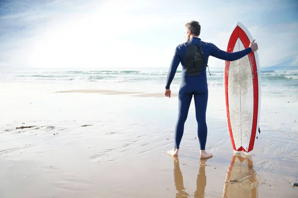 Surfista em pé na praia de areia — Fotografia de Stock