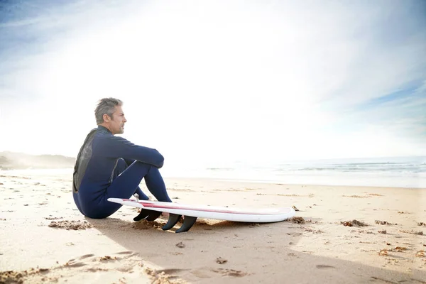 Surfista sentado na praia de areia — Fotografia de Stock