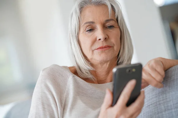 Donna sul divano con smartphone — Foto Stock