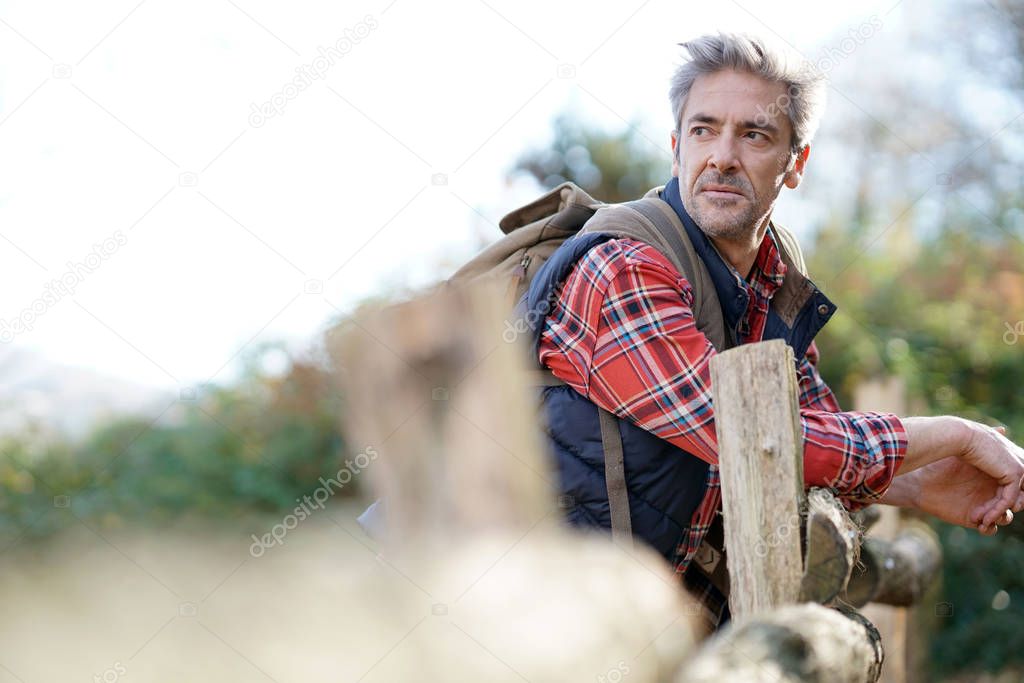 Hiker relaxing by fence