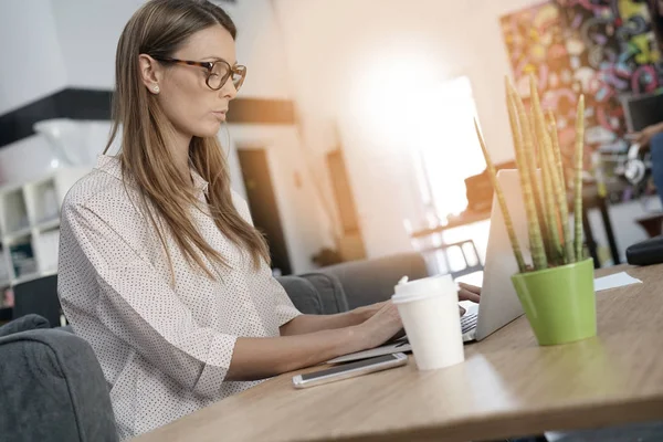 Jonge vrouw werkt op laptop — Stockfoto