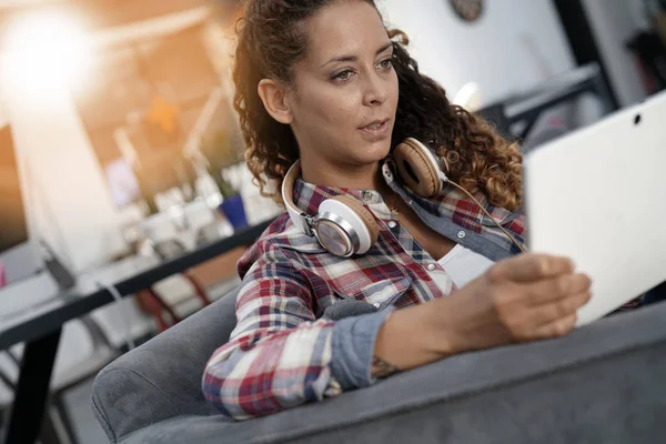 Trendgirl sitzt auf Sofa mit Tablet — Stockfoto