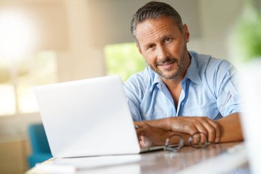 dizüstü bilgisayarda çalışan olgun adam 