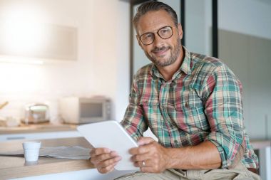 Evde dijital tablet kullanan adam