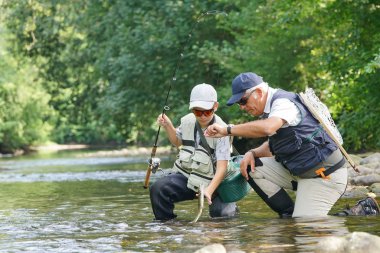 Baba ve oğul alabalık yakalama