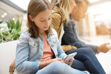 Aile gün genel bankta oturan alışveriş merkezinde alışveriş üzerinde