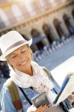 Smartphone ve harita kullanan kadın