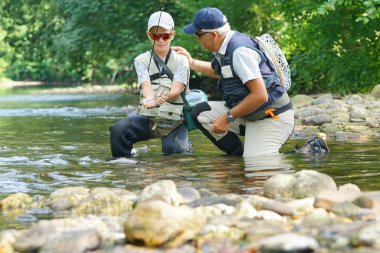 Baba ve oğul alabalık yakalama