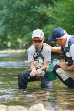 Baba ve oğul alabalık yakalama