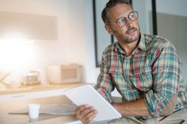 Evde dijital tablet kullanan adam