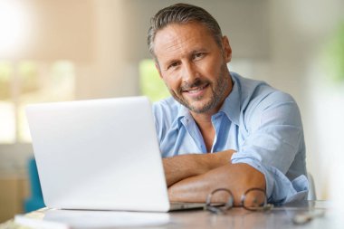 dizüstü bilgisayarda çalışan olgun adam 