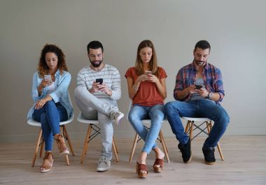 Bekleme odasında smartphones vasıl arayan genç insanlar