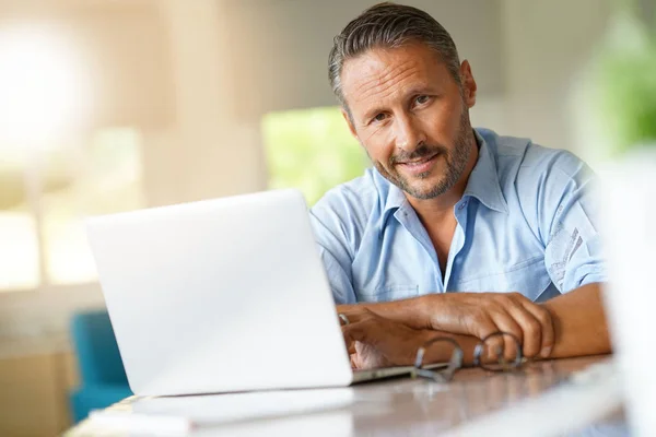 Volwassen man aan het werk op laptop — Stockfoto