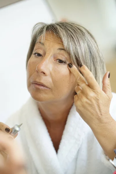 Senior vrouw voor spiegel — Stockfoto