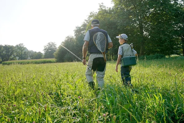 Papi e hijo caminando en el campo — Foto de Stock