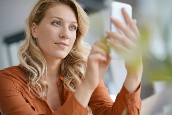 Blondine nutzt Smartphone — Stockfoto