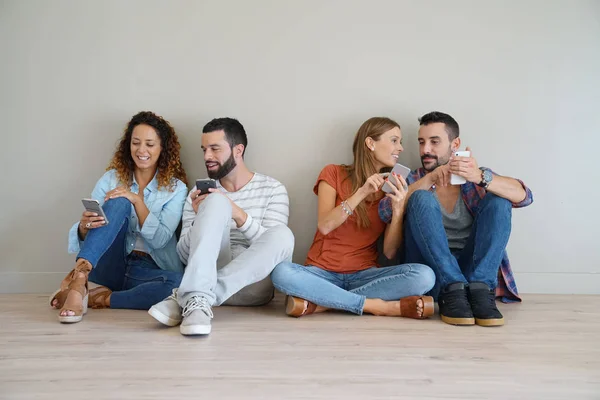 Group of friends using smartphones — Stock Photo, Image