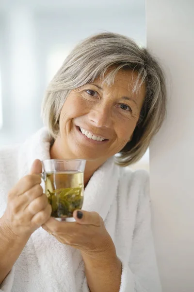 Woman in bathrobe drinking — Stock Photo, Image