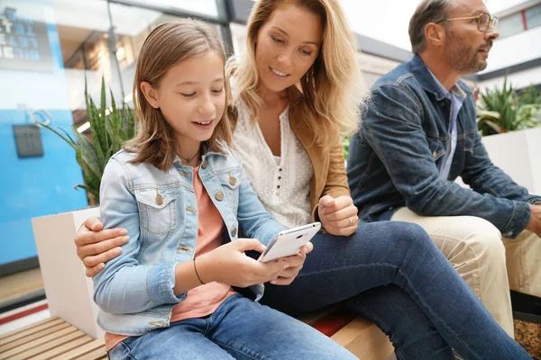 Aile gün genel bankta oturan alışveriş merkezinde alışveriş üzerinde