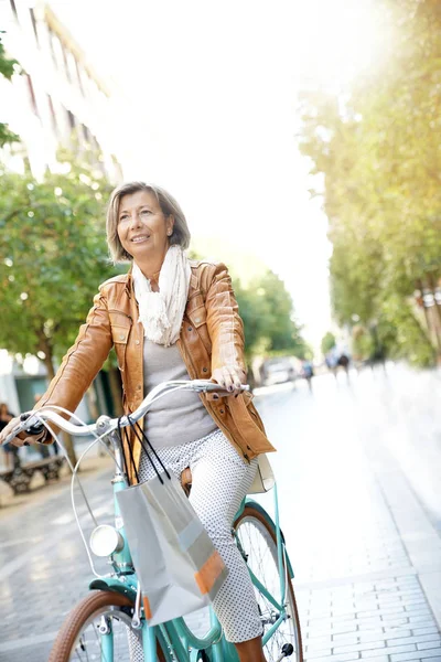 Mujer mayor montar bicicleta de la ciudad — Foto de Stock