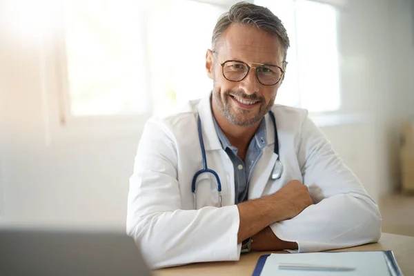 Médico sentado em consultório médico — Fotografia de Stock