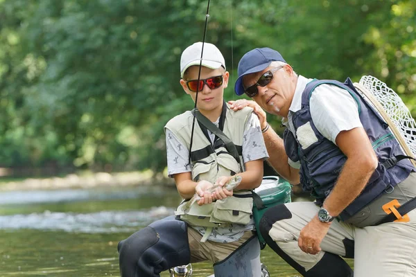 Vater und Sohn fangen Regenbogenforellen — Stockfoto