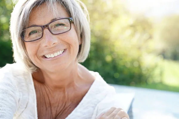 Mujer con gafas que se relaja afuera — Foto de Stock