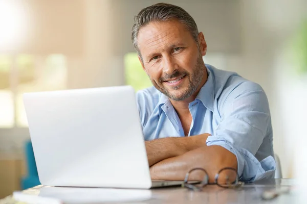 Volwassen man aan het werk op laptop — Stockfoto