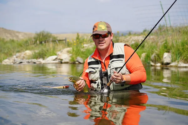 Fisherman catching brown trout — Stock Photo, Image