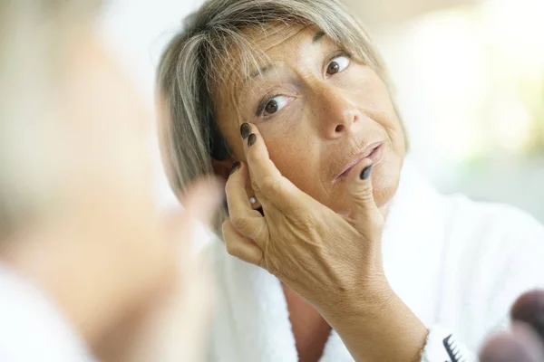 Senior vrouw voor spiegel — Stockfoto