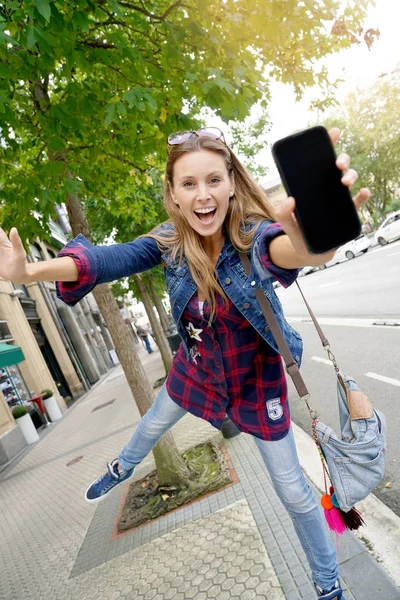 Mädchen zeigt Smartphone-Bildschirm — Stockfoto