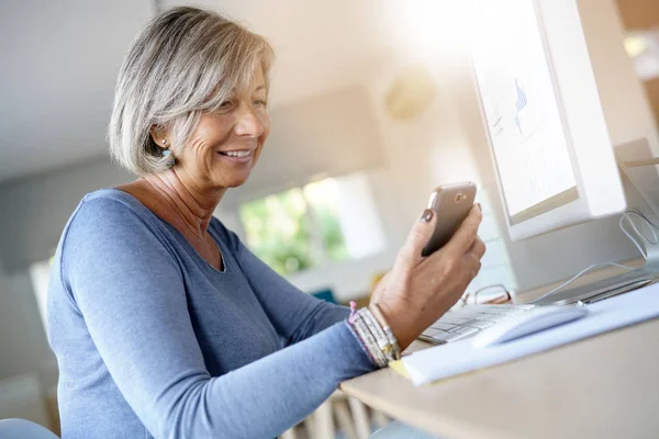 Woman working in office using smartphone — Stock Photo, Image