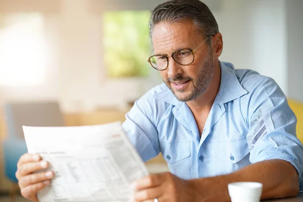 Uomo con gli occhiali che legge il giornale — Foto Stock