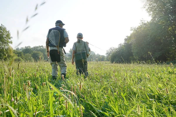 Daddy and son walking in field