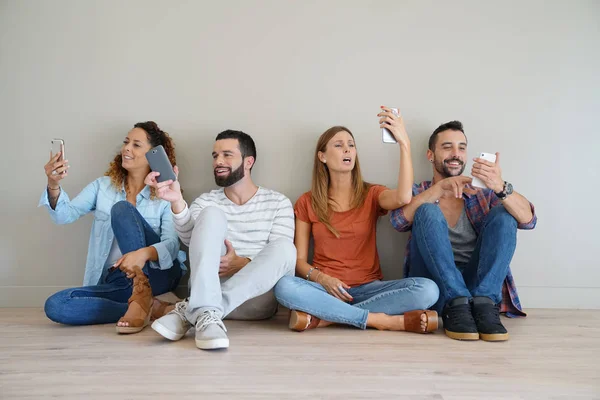 Groep van vrienden met behulp van smartphones — Stockfoto