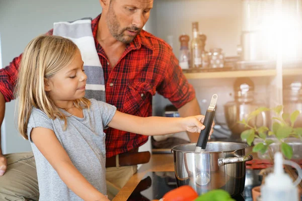 Daddy with daughter cooking together in home kitchen