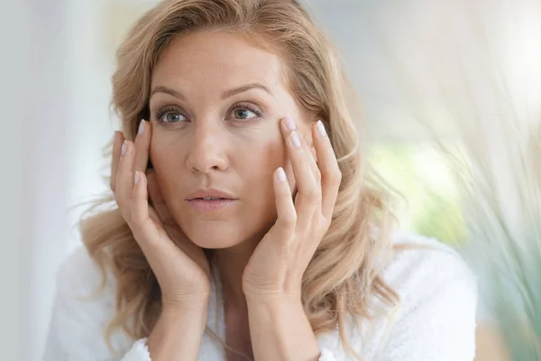 Mujer aplicando crema antienvejecimiento —  Fotos de Stock