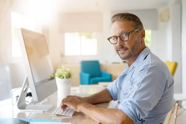 Älterer Mann arbeitet von zu Hause aus — Stockfoto