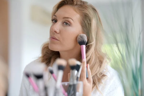 Mujer aplicando maquillaje Fotos de stock