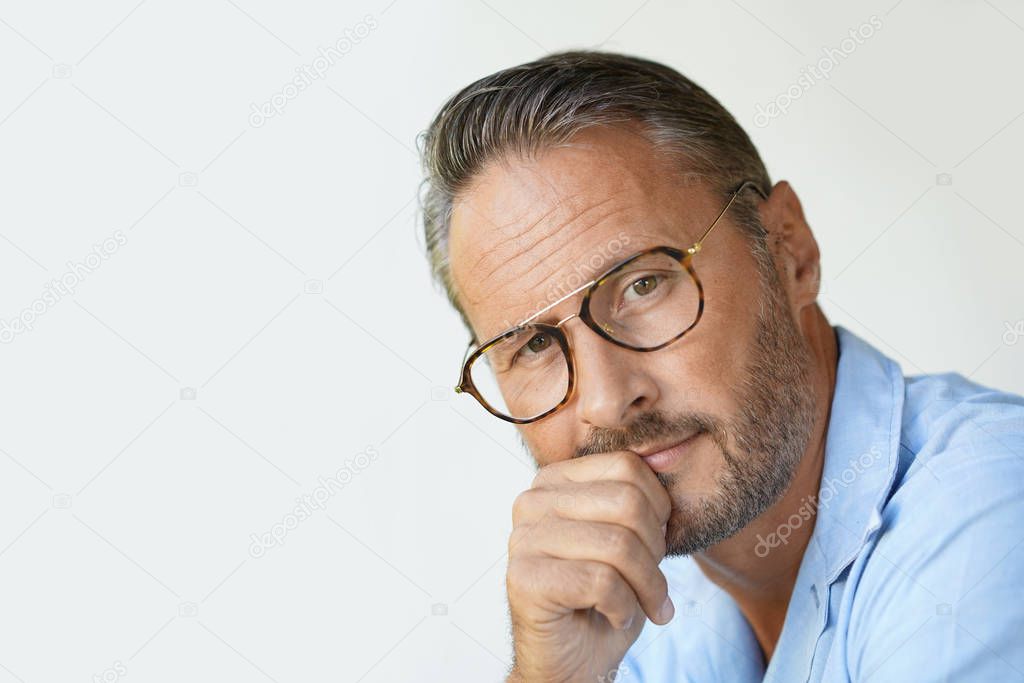 Portrait of mature man with eyeglasses and blue shirt, isolated