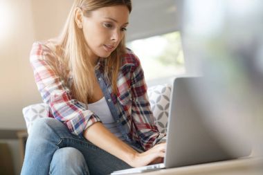 Evde Dizüstü bilgisayar kullanan kadın