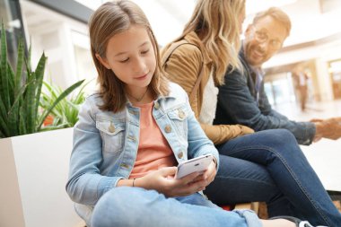 Aile gün genel bankta oturan alışveriş merkezinde alışveriş üzerinde