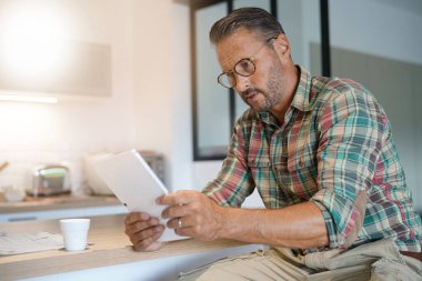 Evde dijital tablet kullanan adam