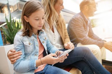 Aile gün genel bankta oturan alışveriş merkezinde alışveriş üzerinde