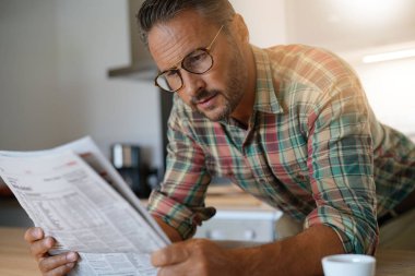 adam evde Gazete okurken