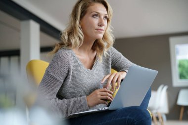 Kadın açılan dizüstü bilgisayar üzerinde