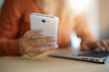 Smartphone ve dizüstü bilgisayar bağlı kadın