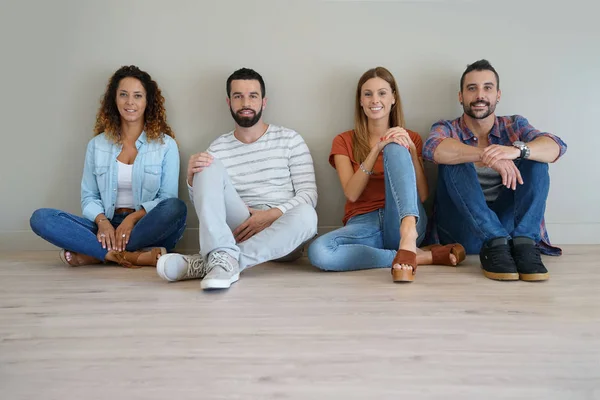 Vrienden zittend op de vloer — Stockfoto