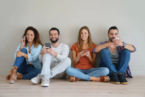 Grupo de amigos usando teléfonos inteligentes — Foto de Stock